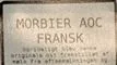 Et udsnit af ostens label, hvor der står Morbier AOC FRRANSK