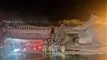 Brandmænd der står på jorden og sprøjter vand på et fly fyldt med røg