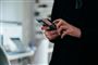 person står med mobiltelefon