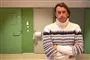 mand i højhalset sweater foran nogle grønne lukkede døre