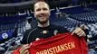 Smilende Lars Christiansen holder rød landsholdstrøje op foran sig