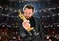 mand står med oscarstatuette