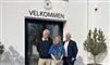 tre spersoner poserer foran indgang 