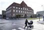 kvinde med barnevogn går foran retsbygning