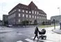 kvinde med barnevogn går foran retsbygning