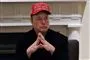 Elon Musk med hænderne samlet foran sig og en kasket med ordene Trump was right about everything