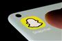 Toppen af en mobiltelefon med Snapchat-emoji på skærmen