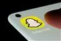 Toppen af en mobiltelefon med Snapchat-emoji på skærmen