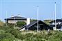 Tre sommerhustage stikker op over nogle grønne hække