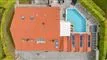 Hus med rødt tag og pool fotograferet fra drone