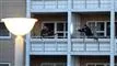 To altaner med personer på. På den højre altan står en mand med et skydevåben og sigter mod den venstre