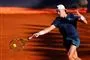 Mand i mørkt tennistøj og hvid kasket