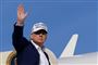Trump på vej ind i i fly med hånden hævet til vink