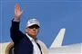 Trump på vej ind i i fly med hånden hævet til vink