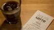 Lottokupon og glas med kaffe på bord