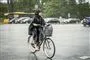 Kvinde på cykel i regnvejr