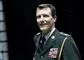 Mand i militæruniform smiler
