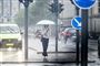 GAdebillede med fodgænger under paraply og MASSER af regn