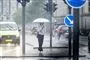 GAdebillede med fodgænger under paraply og MASSER af regn