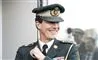 en prins i uniform smiler bredt