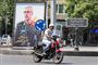En mand på motorcykel kører forbi plakat med den dræbte iranske stabschef