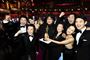 mennesker står med oscarstatuette