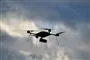 En drone på himlen med skyer som baggrund