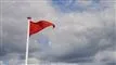 et rødt flag på en strand