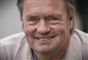 en mand smiler til fotografen
