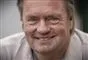 en mand smiler til fotografen