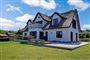 Stort hvidt sommerhus med flot stråtag