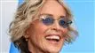 Smilende Sharon Stone med lyst pagehår og blåtonede briller