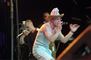En mand med hvid cowboyhat med det amerikanske flag rapper med mikrofon for munden