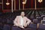 en mand i lyserød habit i en teatersal