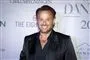 Mand smiler med pressevæg som baggrund