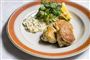 Tre fiskefrikadeller på en tallerken med lidt remoulade, citron og grønt