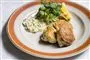 Tre fiskefrikadeller på en tallerken med lidt remoulade, citron og grønt