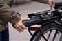 person sætter batteri på cykel 