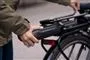 person sætter batteri på cykel 