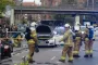 En masse brandfolk foran en hvid Tesla med åben kølerhjelm og døre