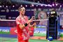 Axelsen i rødt spilletøj kiggende på sin badmintonketsjer
