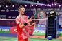 Axelsen i rødt spilletøj kiggende på sin badmintonketsjer