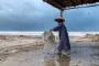 Kvinde med plastpose på strand