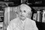 Sort hvid-billede af Einstein, der sidder med et skævt smil