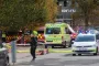 Ambulance, politivogn og flere brandbiler ses bag en politiafspærring