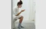 kvinde sidder på toilet med mobiltelefon
