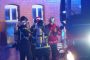 Tre brandfolk og en indsatsleder står foran rød bygning