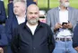 Anders Holch Povlsen står med hænderne bag ryggen på tilskuerpladserne på et stadion