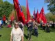 Kvinde går foran gruppe med røde faner