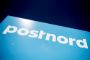Lyseblåt Postnord-skilt set i frøperspektiv
